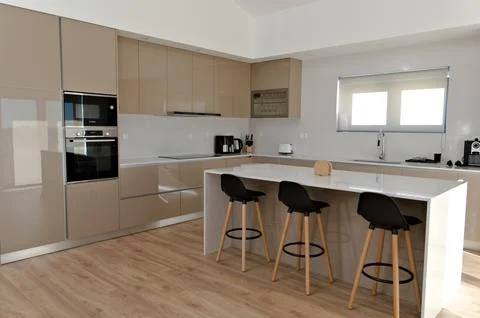 Part of big beige kitchen with table with high black wood chairs 写真素材