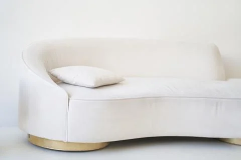 Part of a bright interior with a beige sofa and pillow. Stylish minimalism in Stock Photos