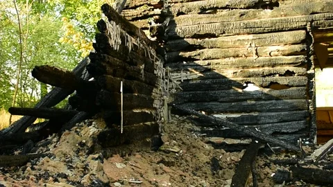 Part of a building after a fire, a burnt log wall Stock Footage 138420098