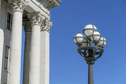 Part of the Capitol building with columns and street lamp on blue sky background Stock Photos