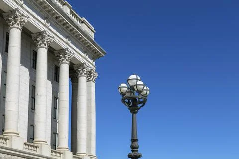 Part of the Capitol building with columns and street lamp on blue sky background Stock Photos