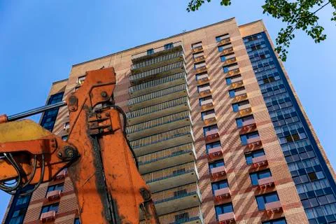 Part of a construction machine with multi-storey building under construction Foto stock
