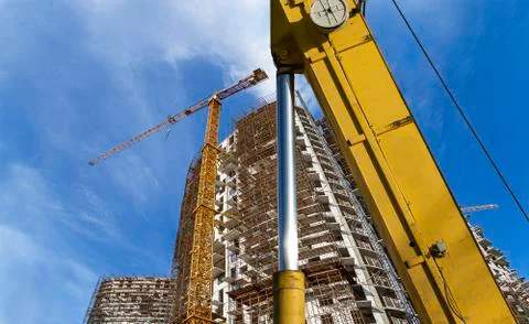 Part of a construction machine  with multi-storey building under construction Stock Photos