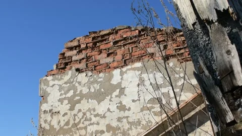 Part of a destroyed brick wall against a blue sky Stock Footage 138515704