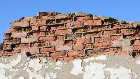 Part of a destroyed brick wall against a blue sky, close-up Stock Footage 138515713