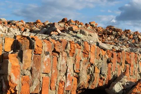 Part of the destroyed wall against a cloudy sky. Stock Photos