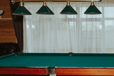 Part of an empty billiard table and lamps above it Stock Photos
