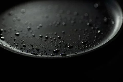 Part of empty cast iron pan of black color with drops of vegetable oil. Close-up Stock Photos