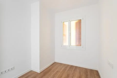Part of an empty room with white walls, brown parquet. Plastic window in wall Photos