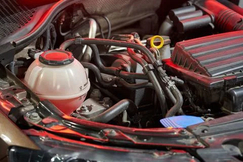 Part of the engine and engine compartment of a car with pipes, an expansion tank Stock Photos