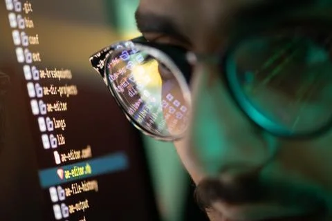 Part of face of young programmer in eyeglasses with reflection of decoded data Stock Photos