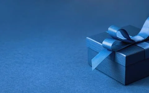 Part of gift box with a blue bow on blue Stock Photos