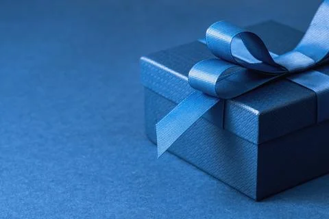 Part of gift box with a blue bow on blue Stock Photos