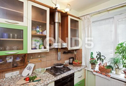Part of green kitchen interior with many utensils and window Stock Photos