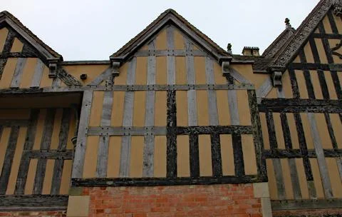 Part of a half timber framed building with ornate carvings on some of the fac 스톡 사진