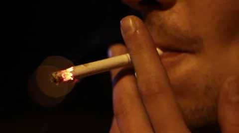 Part of the human face, smoking a cigarette on the street at night and releasing Video stock 67158680