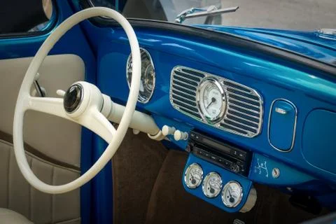 Part of the interior of blue old timer car with steering wheel, speedometer, oil Stock Photos