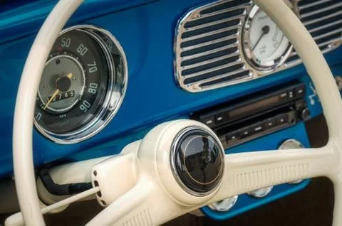 Part of the interior of blue old timer car with steering wheel, speedometer, oil Stock Photos