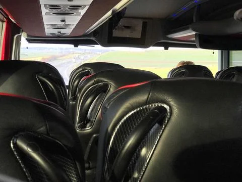 Part of the interior of a bus with black leather seats. Stock Photos