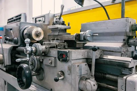 Part of lathe in workshop is close-up. Old lathe for metal processing stands in Stock Photos