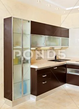 Part of modern kitchen interior with cupboard in warm tones Stock Photos