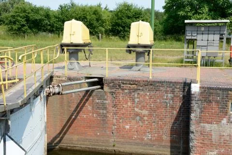 Part of old sluice gate and electric devices on embankment Stock Photos