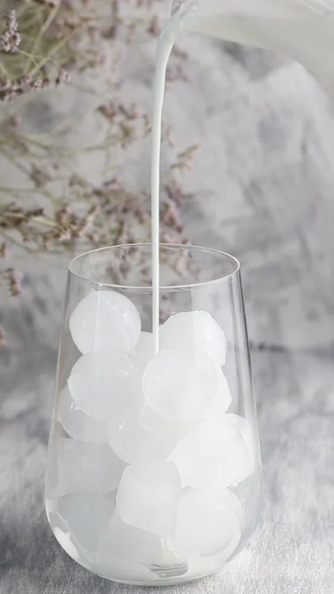 Part of the preparation of cold coffee. Milk is poured into a glass glass with Stock Footage 160815252