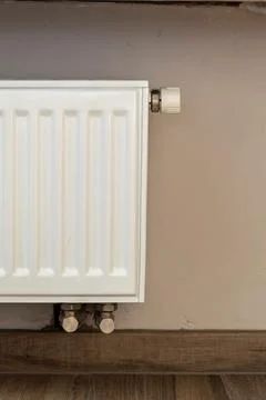 A part of a radiator of a central heating system. The radiator is white and w Foto stock