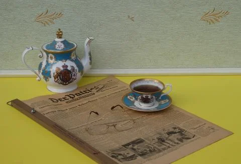 A part of a tea set and reading glasses on an old German newspaper Stock Photos
