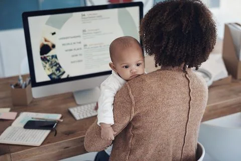 Part time student, full time mom. a young woman using a computer while caring Stock Photos