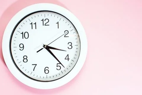 Part of a white wall clock. Close-up image of a plastic wall clock on a pink  Stock Photos