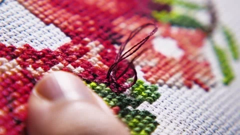 Part of working process over a beautiful cross stitch embroidery. Slow motion Stock Footage 257702448