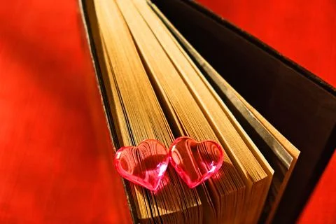 Partial blur Two glass red hearts on pages of old book, Stock Photos