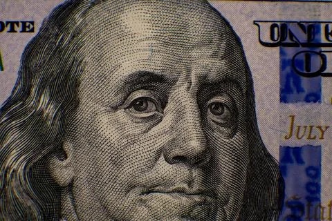 Partial close-up of u.s. one hundred dollar bill with blurred face Foto stock