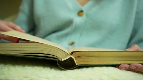 Partial close up view of book in girl's hand. Reading in cosy atmosphere Video stock 236316703