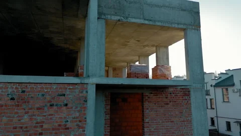 Partial construction of a brick and concrete building, Sunlight streams through Stock Footage 300590071