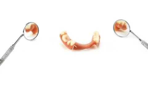 Partial denture between two dental mirrors Stock Photos