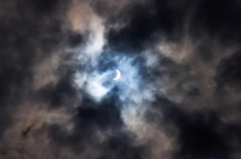 Partial eclipse of the sun during the cloudy weather Stock Photos
