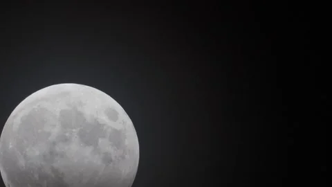 Partial Lunar Eclipse on a Bright Full Moon against Dark Sky - Raising Stock Footage 260444671