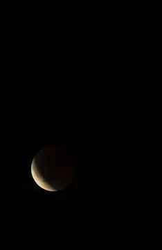 Partial lunar eclipse glowing in the dark night sky Stock Photos