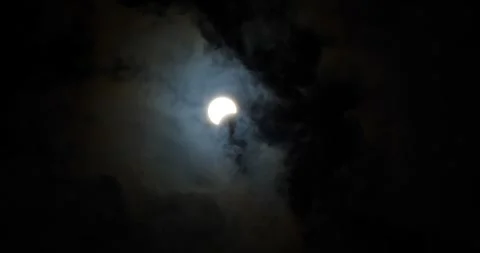 Partial lunar eclipse observed from a cloudy night sky in October Stock Footage 281706319