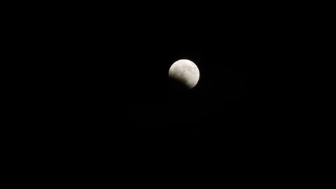 Partial lunar eclipse seen over Caracas amid heavy clouds, VENEZUELA, VE - 28 Au Video stock 343824667