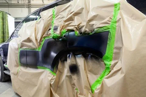 Partial painting of the side elements of the body of a black SUV car after an Stock Photos