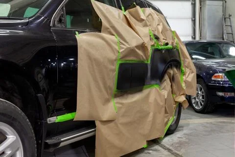 Partial painting of the side elements of the body of a black SUV car after an Stock Photos