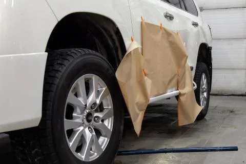 Partial painting of the side elements of the body of a white SUV car after an Stock Photos