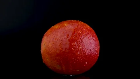 Partial Rotation of Red Sicilian Orange with Water Dripping on Black Background Stock Footage 312148013