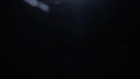 A partial silhouette hand reveals diamonds or gemstones in the light with black  Видео 117800333