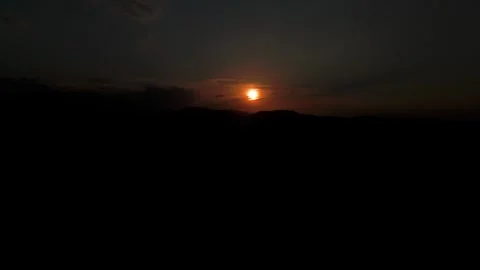 Partial Solar Eclipse above Dark Mountain Horizon Stock Footage 344441140
