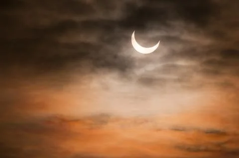 Partial solar eclipse and clouds morning sky Stock Photos