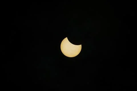 Partial solar eclipse captured against dark sky. Stock Photos